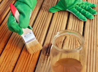 Aplicación de aceite protector sobre tabla de madera tras reparar una zona dañada por humedad en Burgos