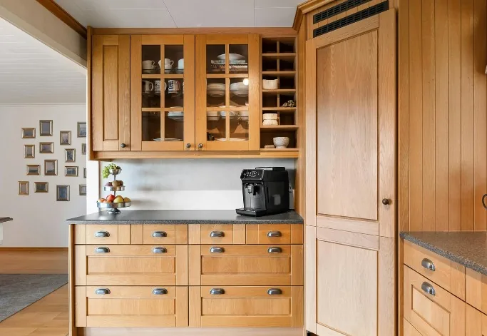 Cocina de madera lacada en gris perla con armarios de vitrina en una vivienda de Burgos capital