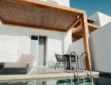 Pérgola de madera con techo de cañizo sobre terraza de ático con piscina y mesa de mimbre en Burgos