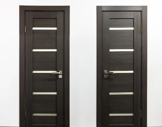 Dos puertas de interior en madera wengué oscura con paneles de vidrio, en showroom, en Villímar, Burgos