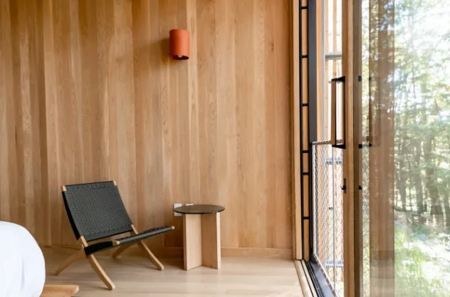 Zona común de alojamiento revestida con madera clara y mostrador de recepción en Burgos