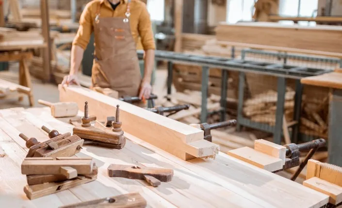 Ebanista trabajando una pieza de madera en un taller de Burgos