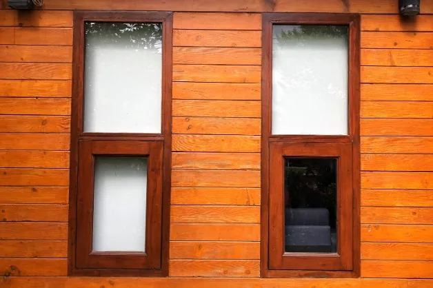 Dos ventanas de madera oscura barnizada con doble acristalamiento en un chalet de Aranda de Duero